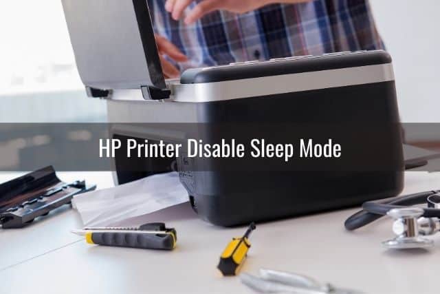 Office black printer being fixed with tools