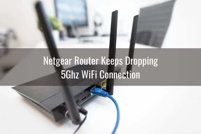 The back of a black router with 3 antennas