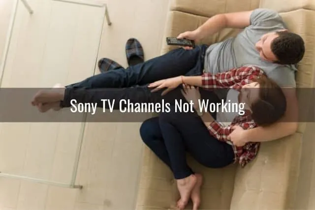 Top view of a couple sitting on a couch and watching TV