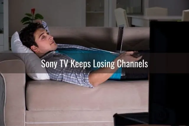 Guy lying on a sofa at night and watching TV