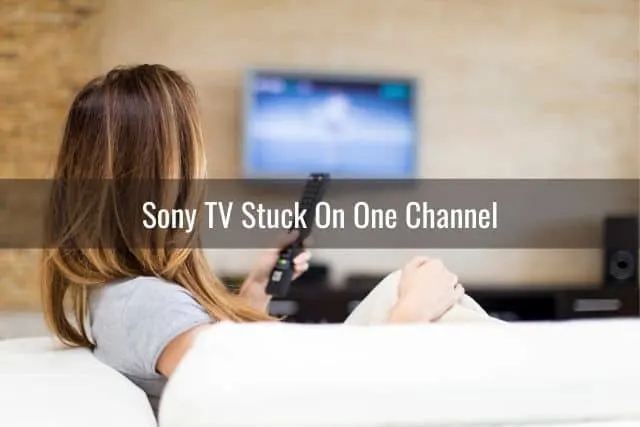 Female sitting on white sofa and watching TV