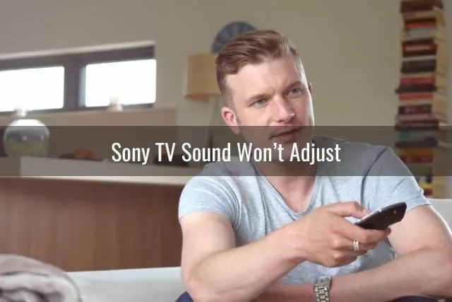 Male in gray shirt holding TV remote