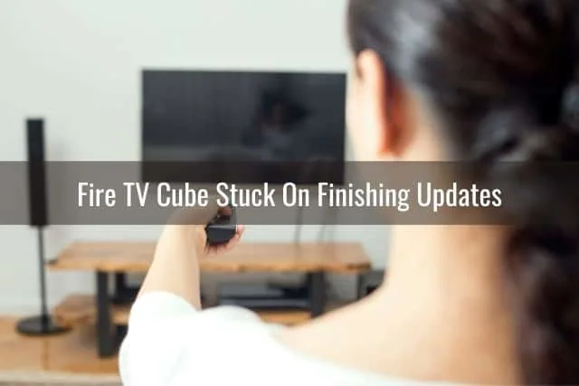 Female pointing TV remote at screen
