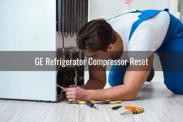 Repairman fixing bottom of refrigerator