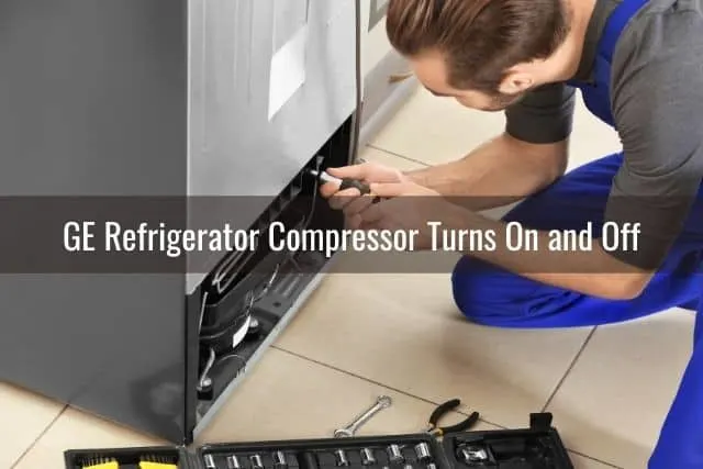 Repairman fixing bottom of refrigerator
