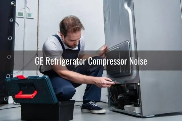 Repairman fixing bottom of refrigerator