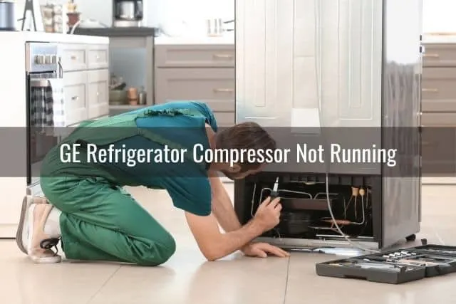 Repairman looking at the bottom of a refrigerator