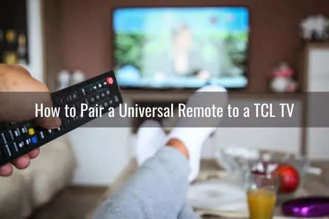 Male sitting on a sofa pointing remote at TV