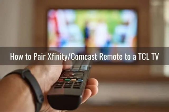 Hand holding and pointing remote at TV