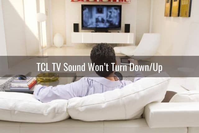 Man sitting on white sofa and watching TV