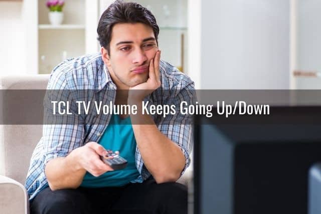 Bored man sitting on sofa scrolling through the TV channels