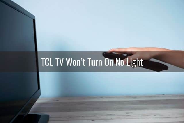 Hand holding remote and pointing it at TV
