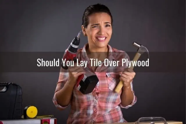 Nervous female with power drill and hammer