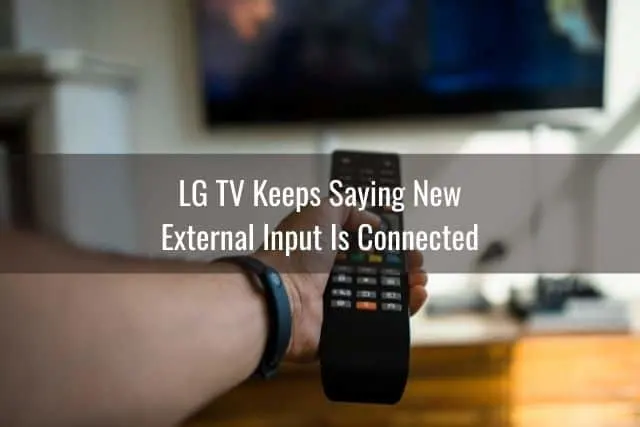 Hand holding pointing TV remote at screen