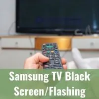 Hand holding TV remote and pointing it at the screen to turn on