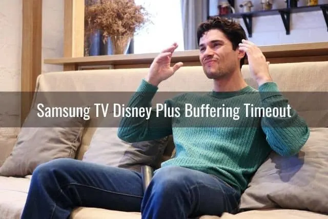 Male sitting on sofa frustrated with hands up in the air