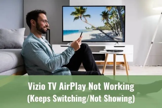 Male using phone while TV is on in the background