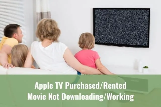 Family of four sitting on sofa watching a TV