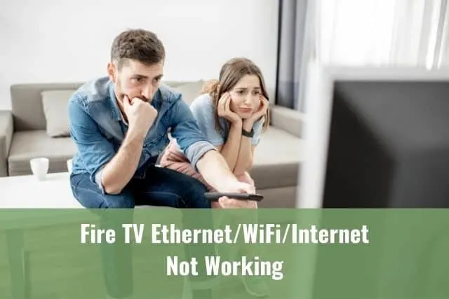 Couple sitting on a couch trying to find something to watch on TV