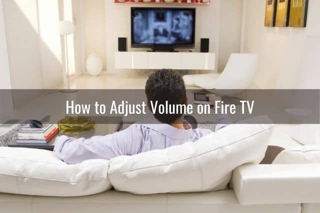 Male sitting on sofa in living room watching TV