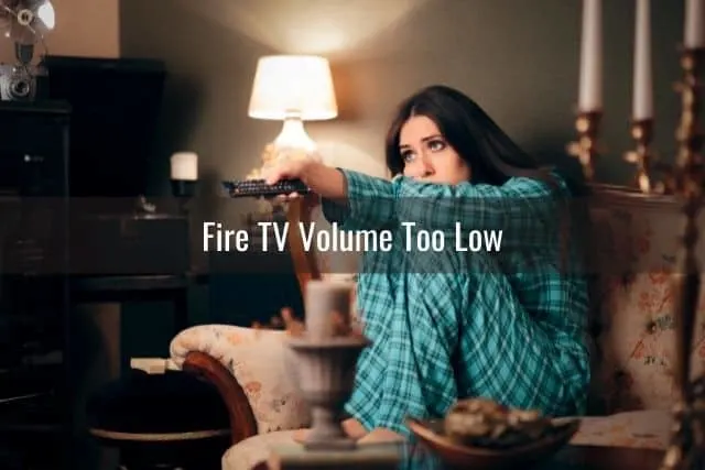 Female in pajamas sitting on sofa watching TV at night