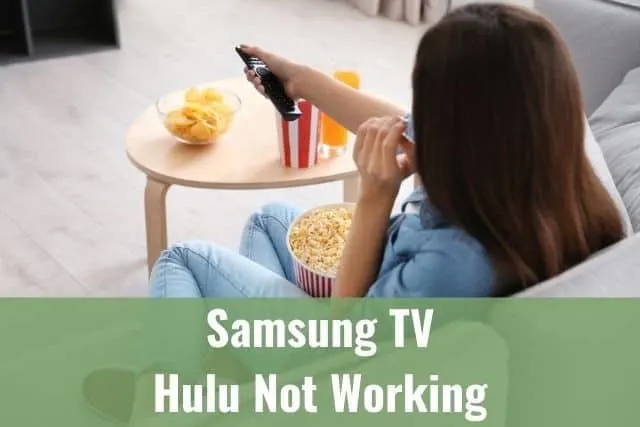 Female sitting on sofa eating popcorn and using remote to change TV programming