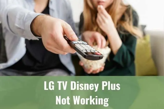 White couple sitting on couch eating popcorn and channel surfing TV with remote