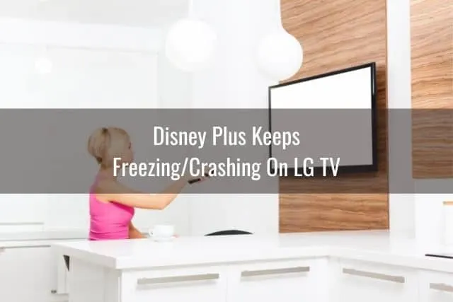 Female sitting on sofa pointing remote at white TV screen