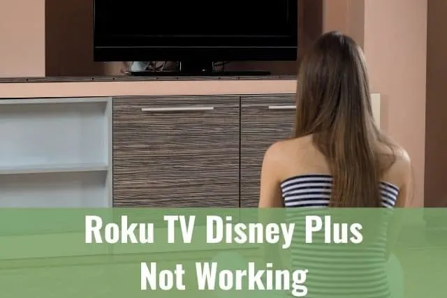Female teenager sitting on living room floor looking at black TV screen