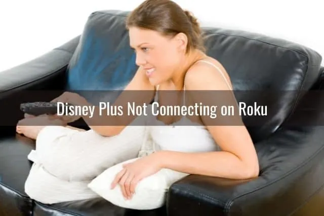 Female sitting on couch changing channels with TV remote