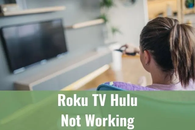 Female sitting on couch and looking at black TV screen