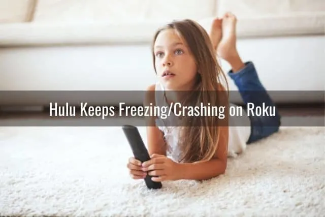 Young girl watching TV on living room carpet floor
