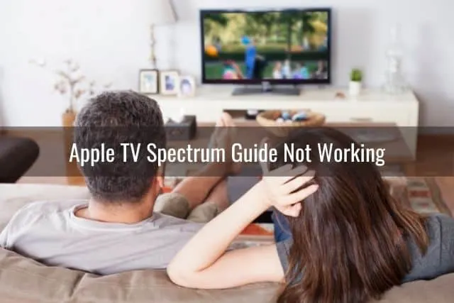 Male and female watching TV show in living room
