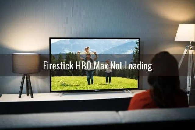 Back view of female watching TV in living room
