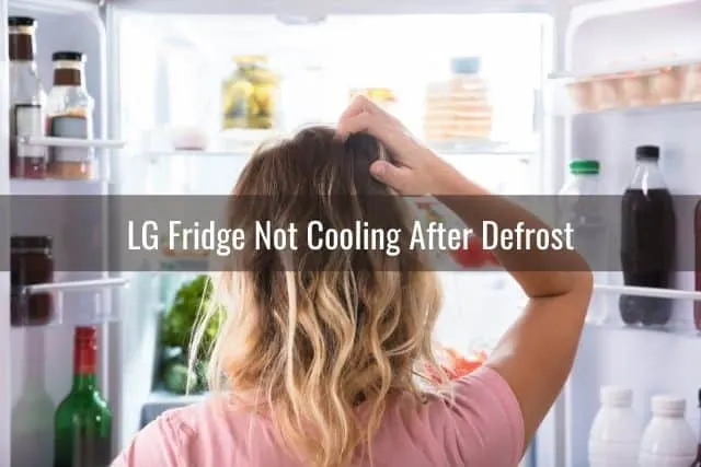 Female scratching head in front of open fridge door
