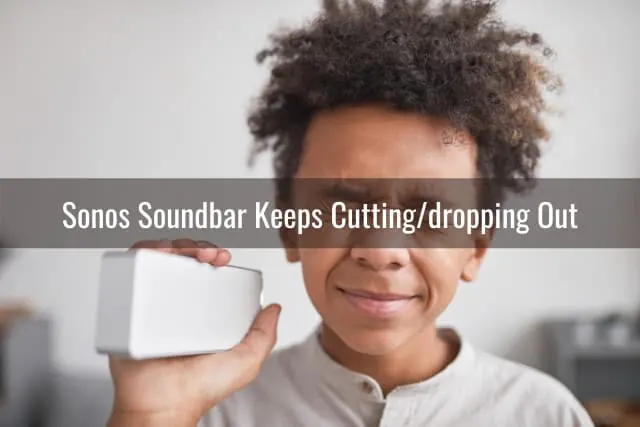 A boy holding a speaker while closing his eyes