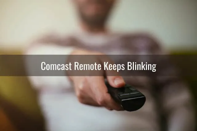 Man holding a remote while pointing at the TV