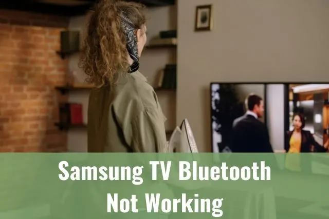 Female standing while watching TV