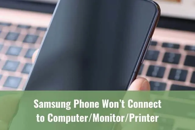 Close up of phone with laptop in the background