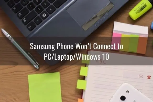 Student desk with black laptop and white phone