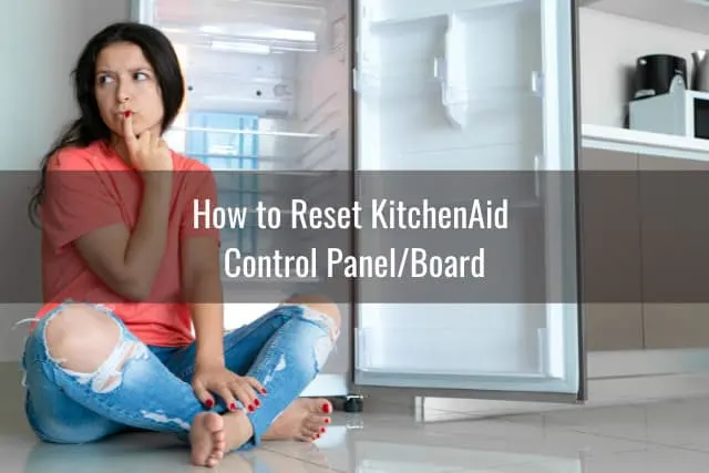 Confused woman sitting while behind the refrigerator
