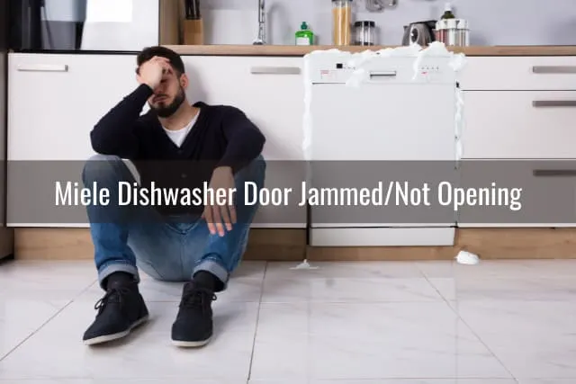 Tired man sitting on the floor behind the dishwasher