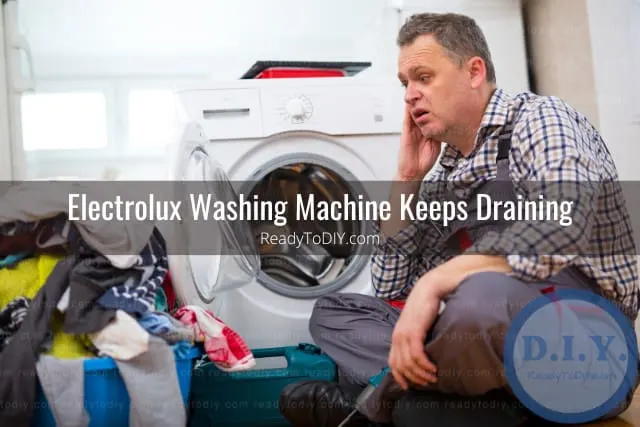 White modern washer with clothes inside