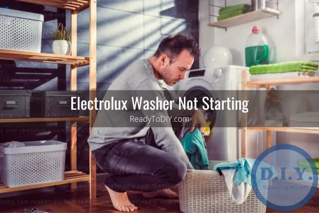 White modern washer with clothes inside