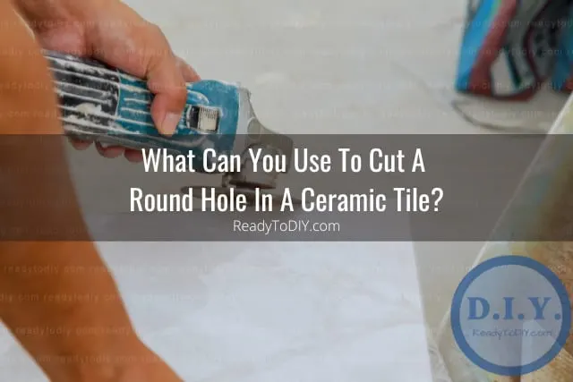 Man cutting ceramic tile in hole
