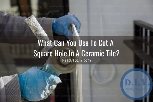 Man cutting ceramic tile in hole